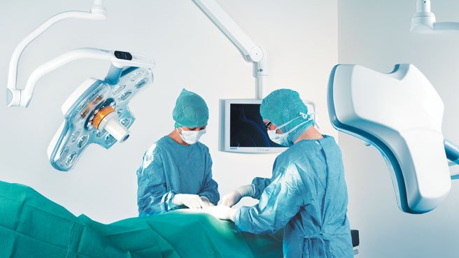 doktori izvode operaciju pod operacionim lampama